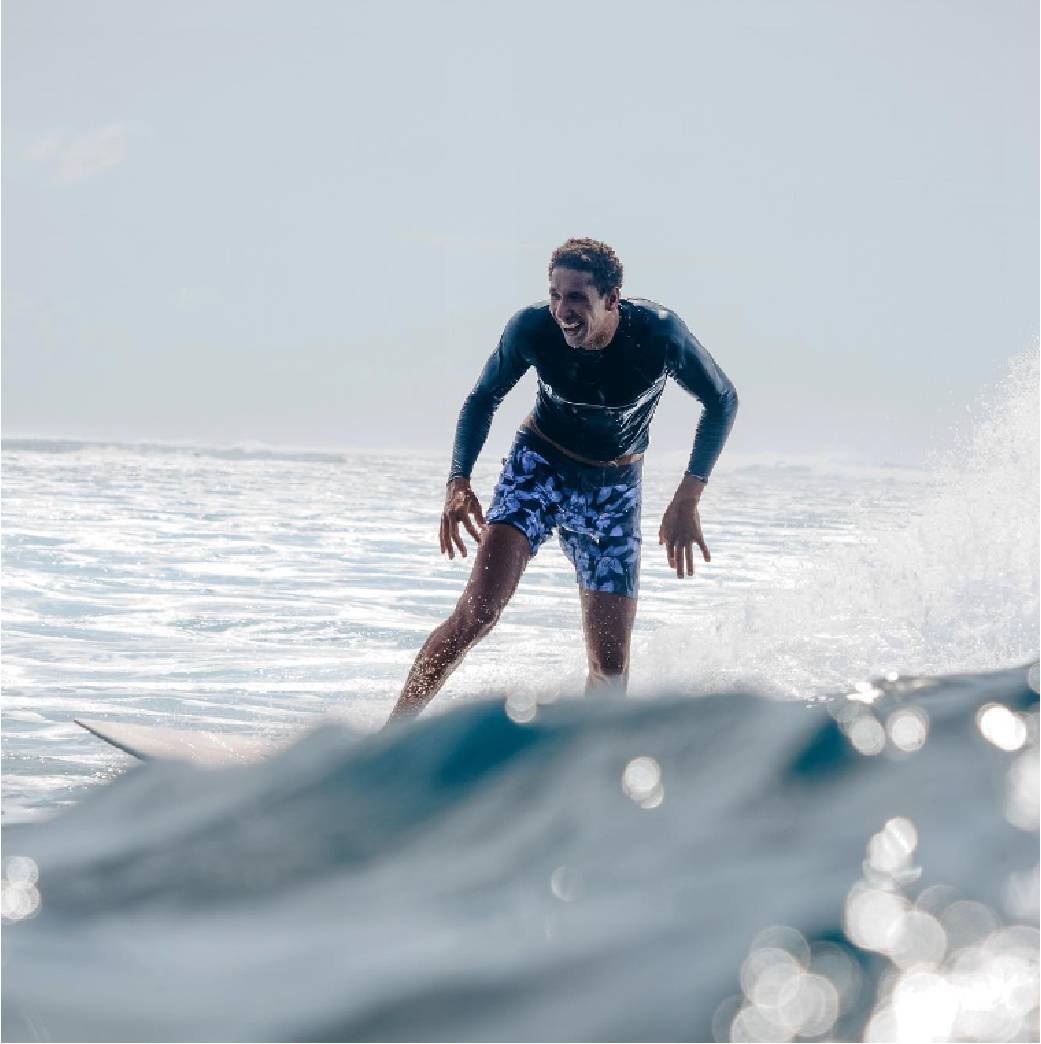 Wenderson Biludo sorrindo e surfando